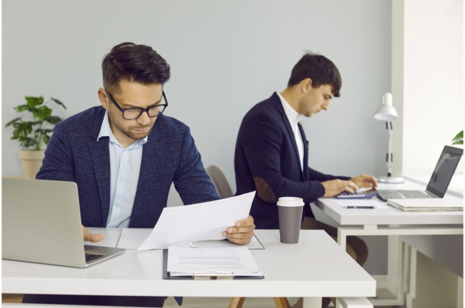 Formateur guidant un apprenant sur un tableau de bord économique
